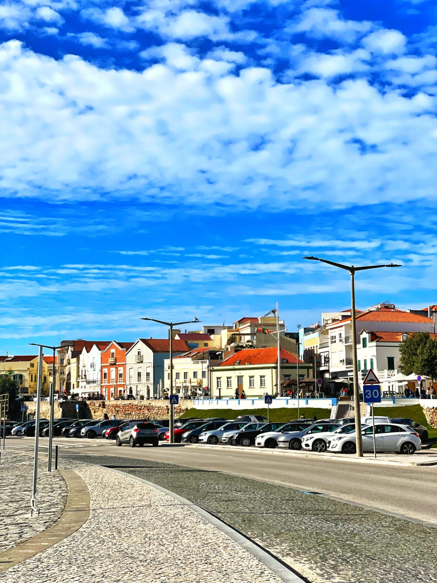 Vibrant street view in a Portuguese town with historic houses under a clear blue sky.