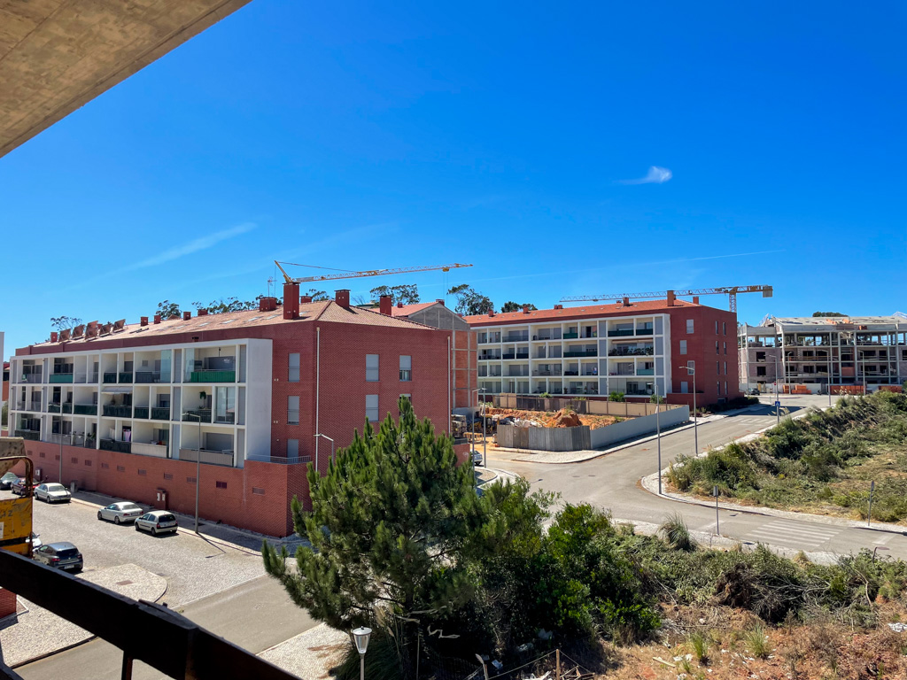 Photo of ongoing construction of residential buildings in Figueira Da Foz with cranes against a clear blue sky, highlighting urban growth.