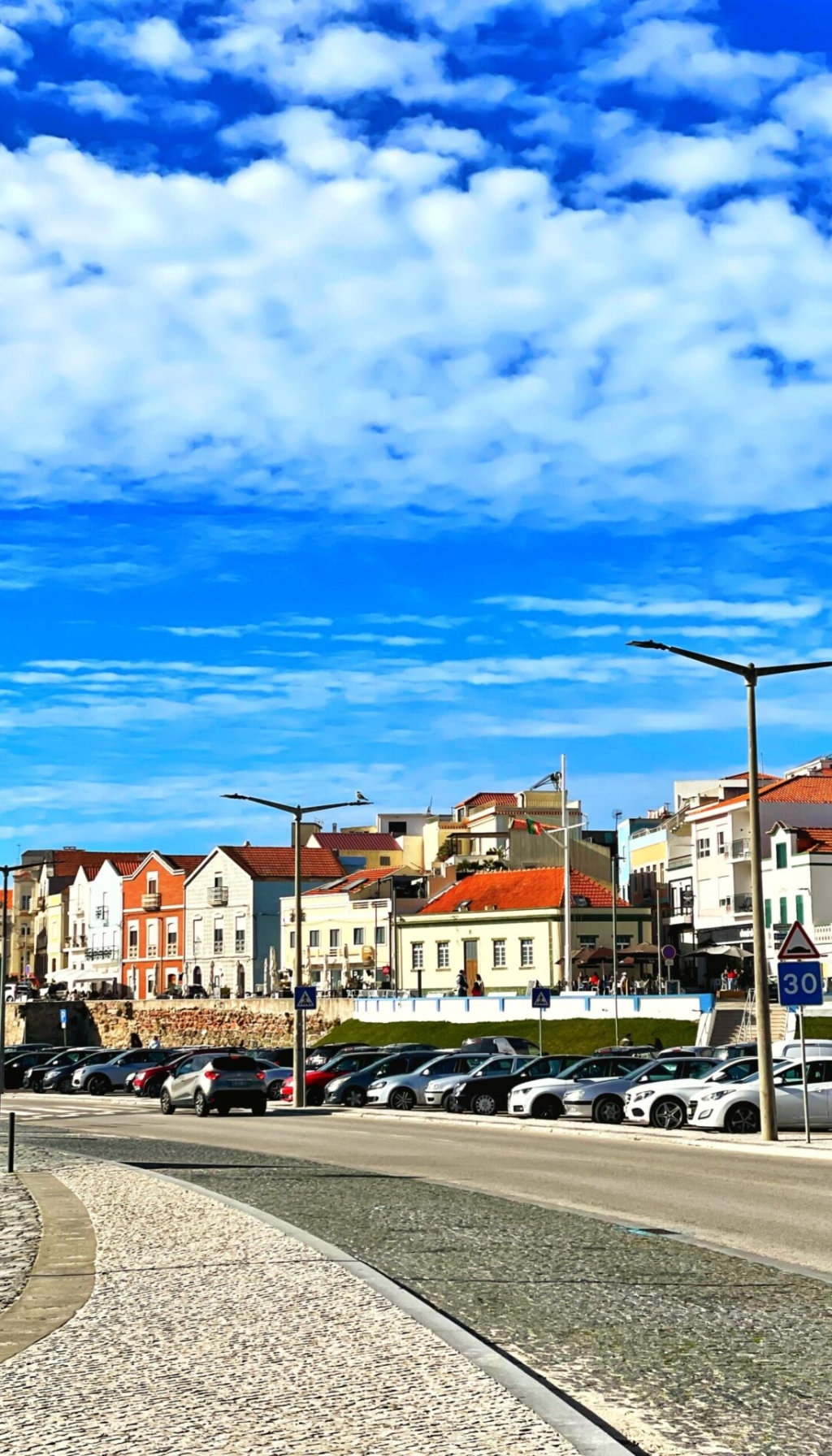 Vibrant street view in a Portuguese town with historic houses under a clear blue sky.